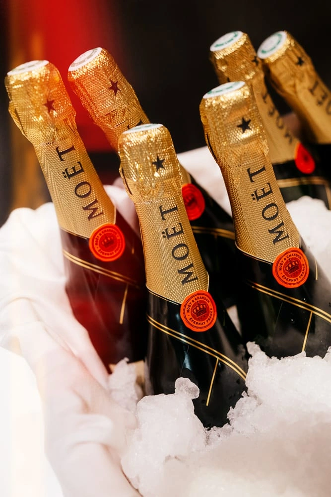 Bouteilles de champagne Moët présentées dans un seau de glace lors d’un reportage événementiel.