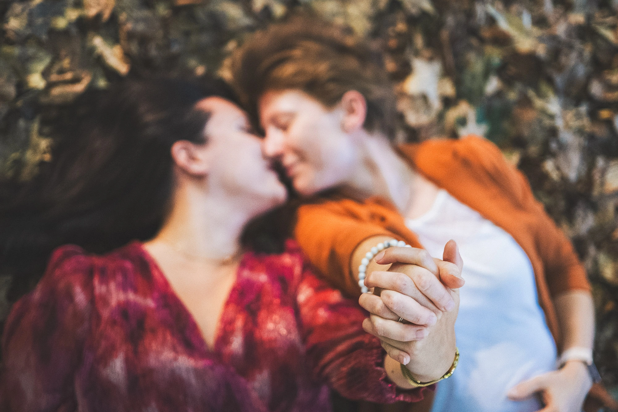 Deux femmes se rapprochant, leurs mains enlacées au premier plan dans une scène en mouvement.