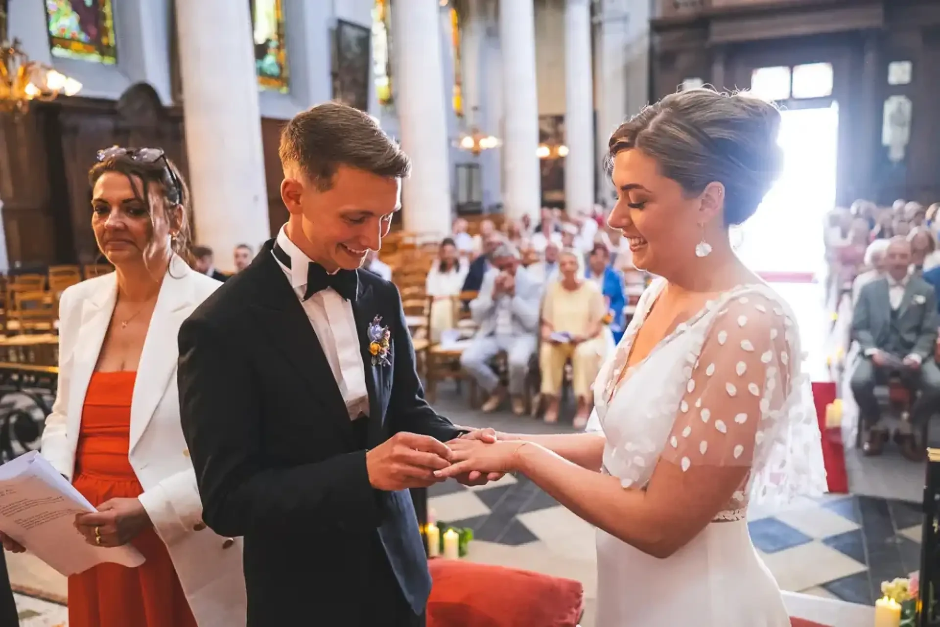 Louis passe l’alliance au doigt de Célia pendant la cérémonie.